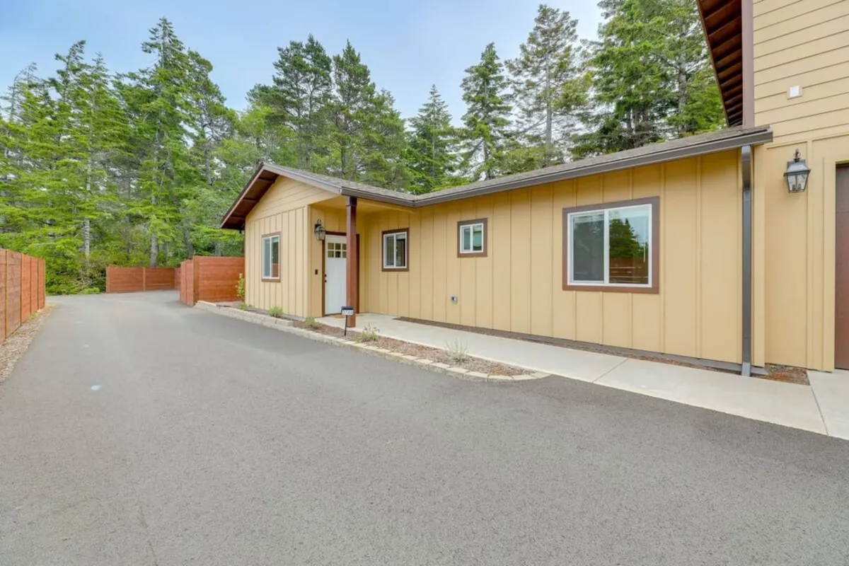 A landscaped pathway leads to the front door of the house, framed by greenery and a welcoming exterior. The setting suggests enjoyable mornings and evenings spent outdoors, with easy access to local explorations.