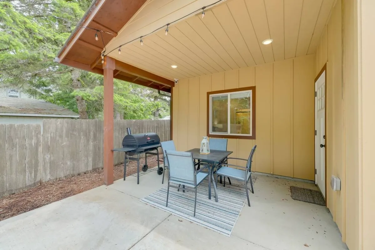 A welcoming outdoor patio area with a grill, table and chairs, and a decorative lantern, designed for outdoor dining and social gatherings. The setting suggests relaxation after a day of exploring nature or enjoying water adventures.