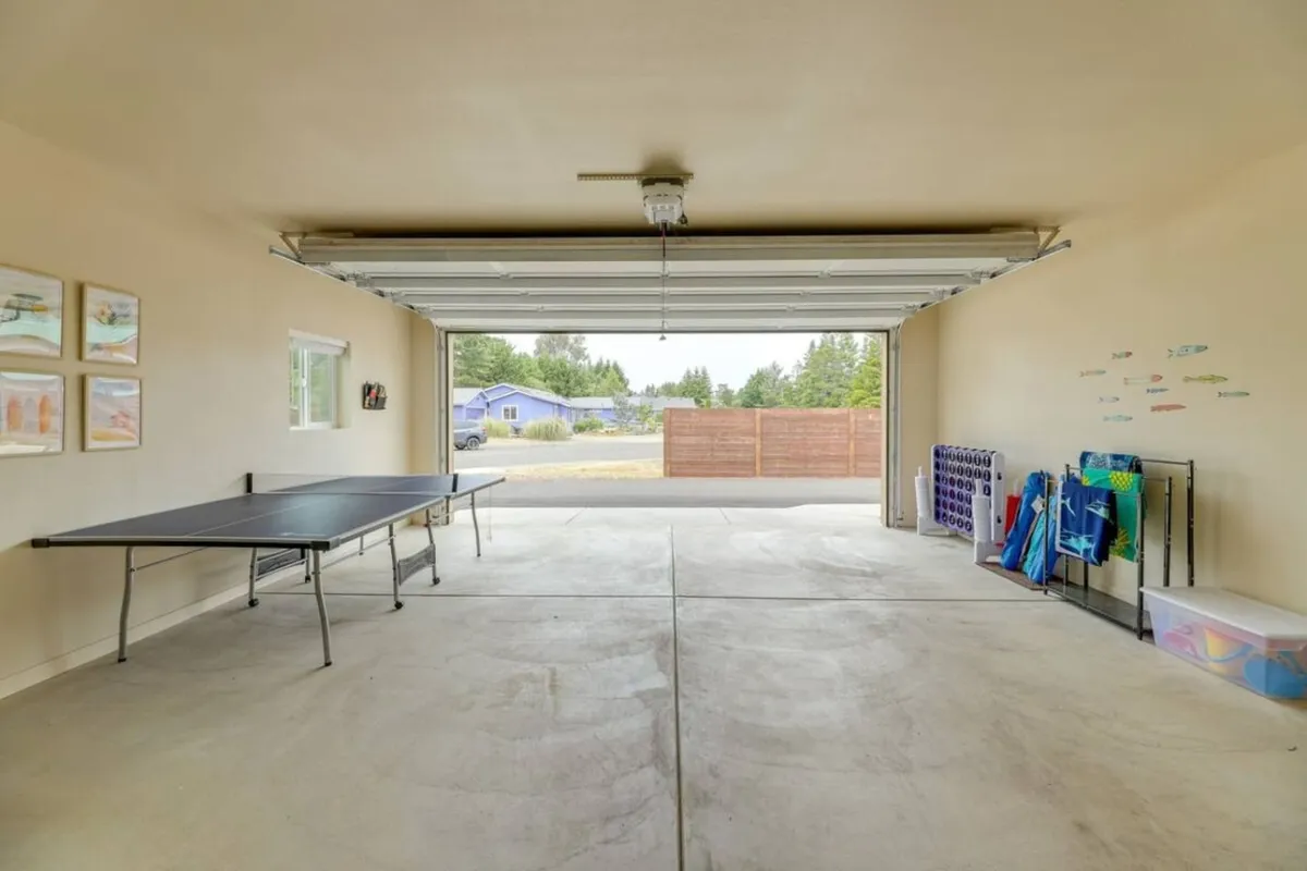 This image captures a ping pong table set up in a brightly lit garage space, with the garage door open and storage racks in the background. The casual arrangement invites group activities and creates an approachable, fun environment for friendly competitions.