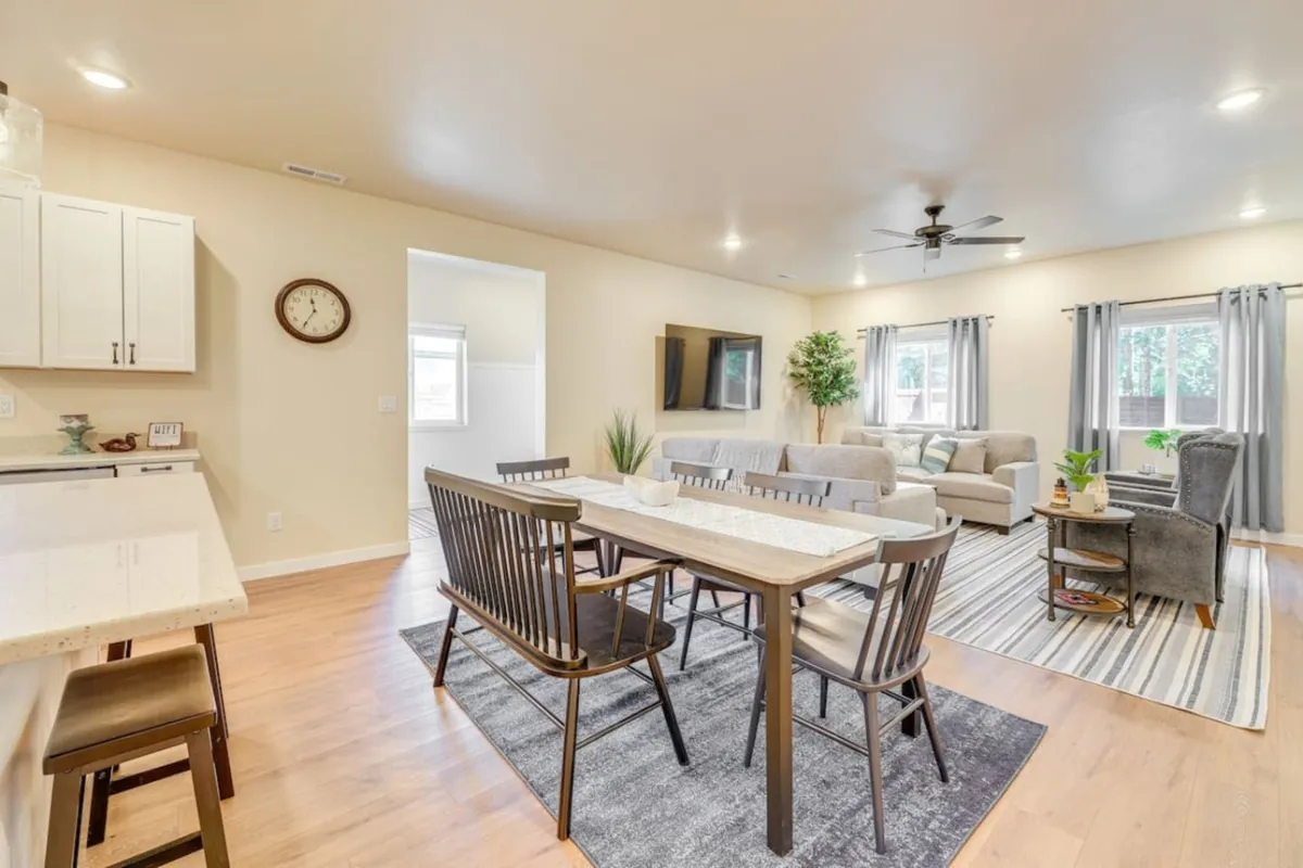 A welcoming interior featuring a dining table next to a spacious couch area and a TV. The space is set up for both communal meals and entertainment, embodying a relaxed, social atmosphere.